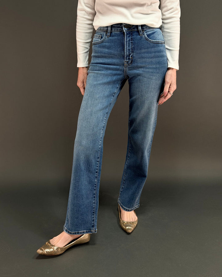 woman wearing straight leg jeans in front of gray background
