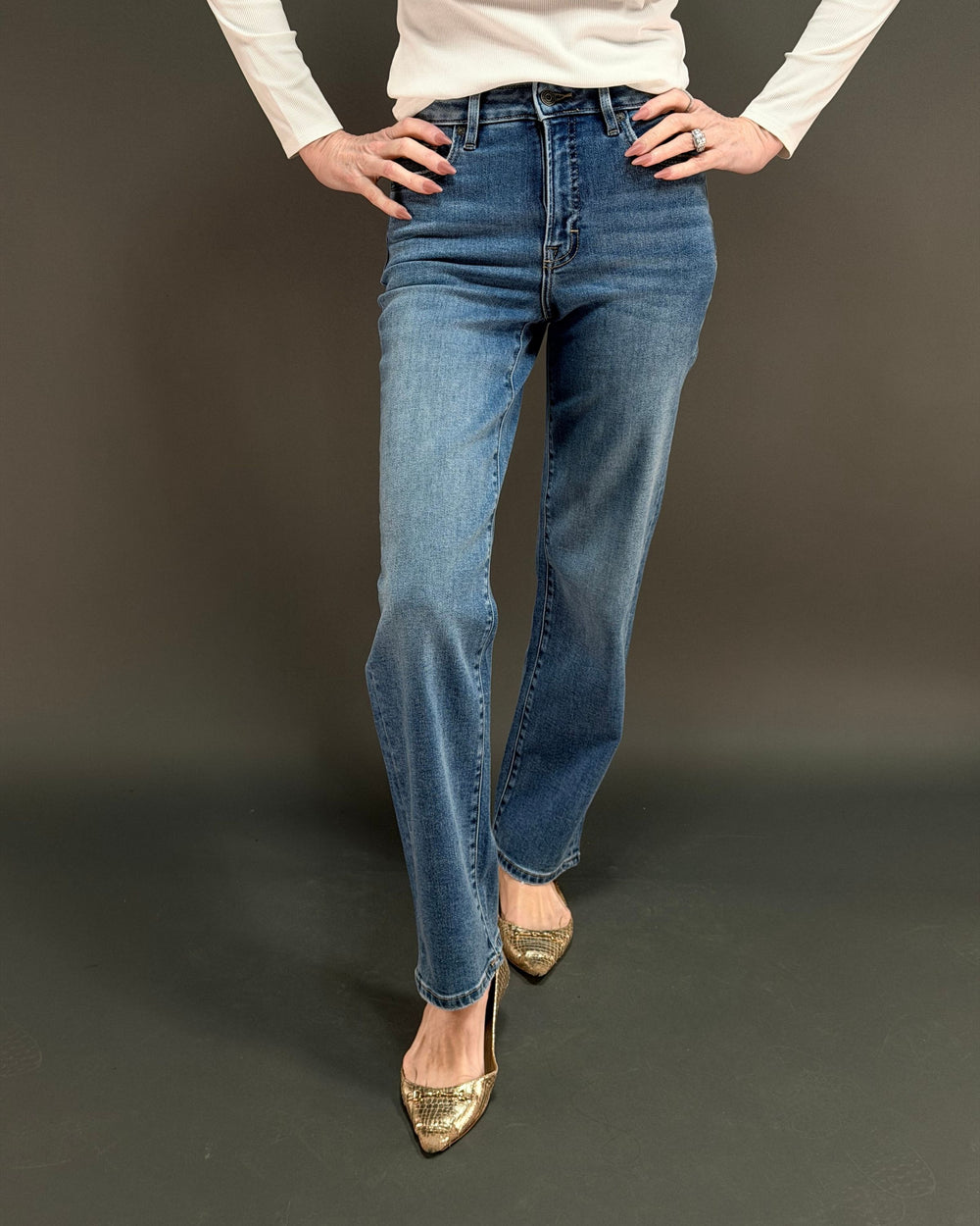 woman wearing straight leg jeans in front of gray background