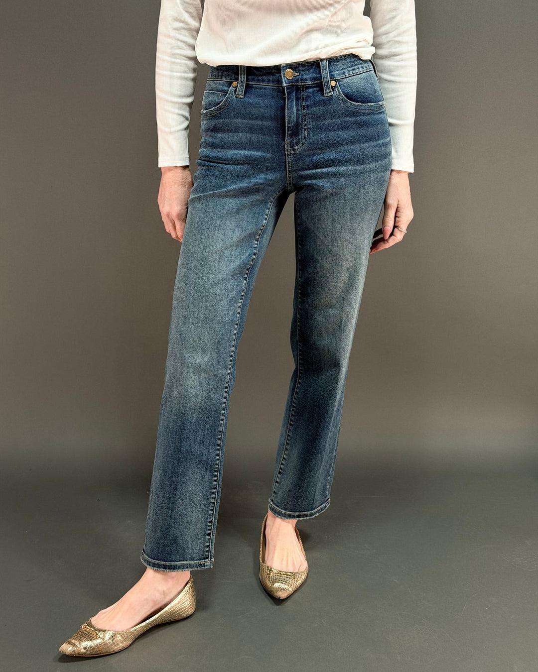 woman wearing straight leg jeans in front of gray background