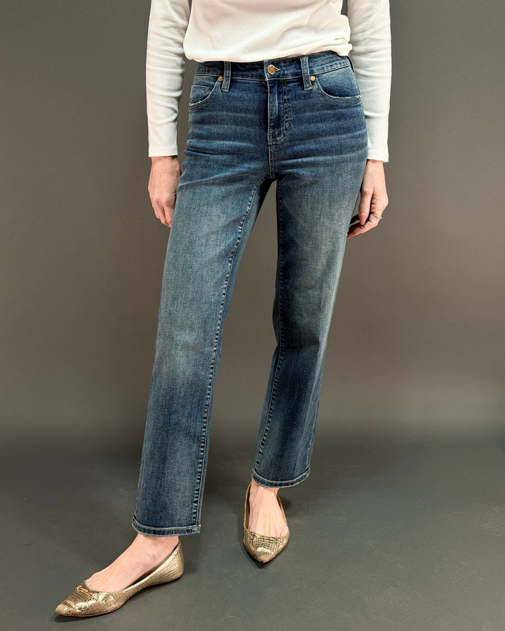 woman wearing straight leg jeans in front of gray background